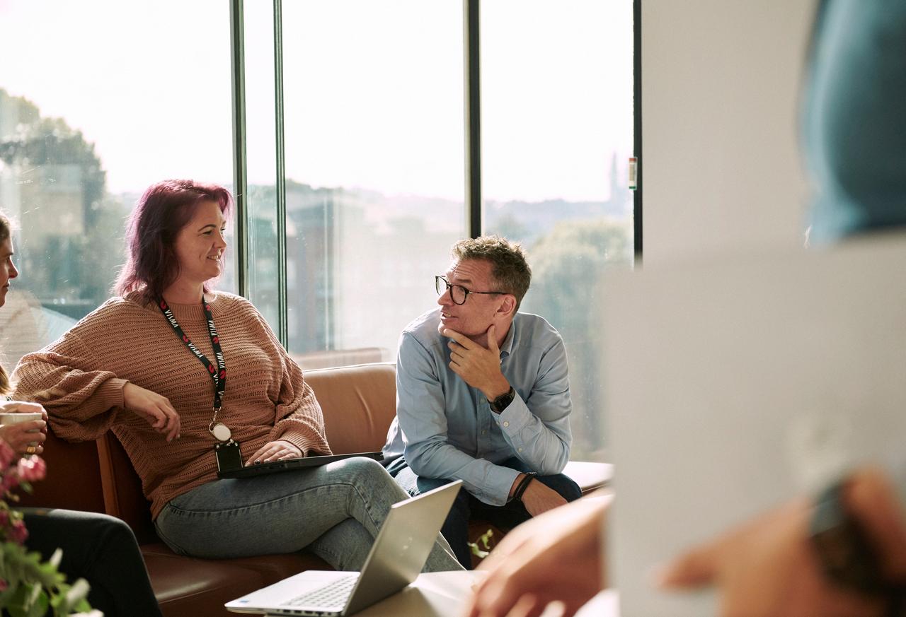 Two colleagues sitting on a couch, talking