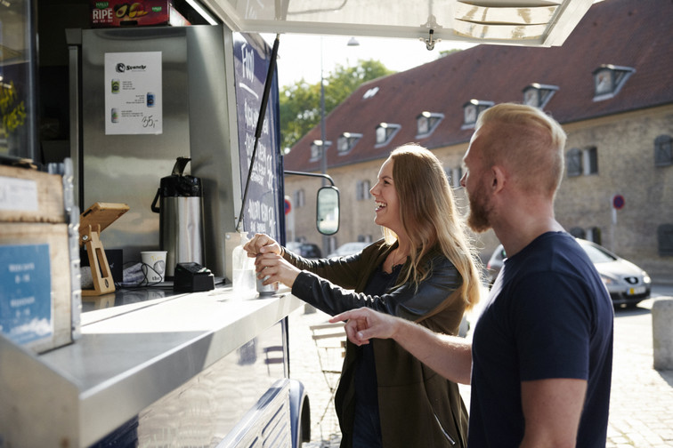 man and woman buying coffee from a coffee truck