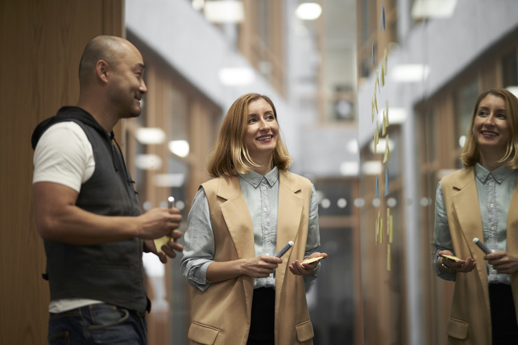 A woman and man brainstorm a design project on a board