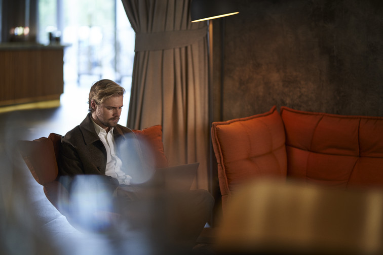 Man sitting in a sofa looking at his computer