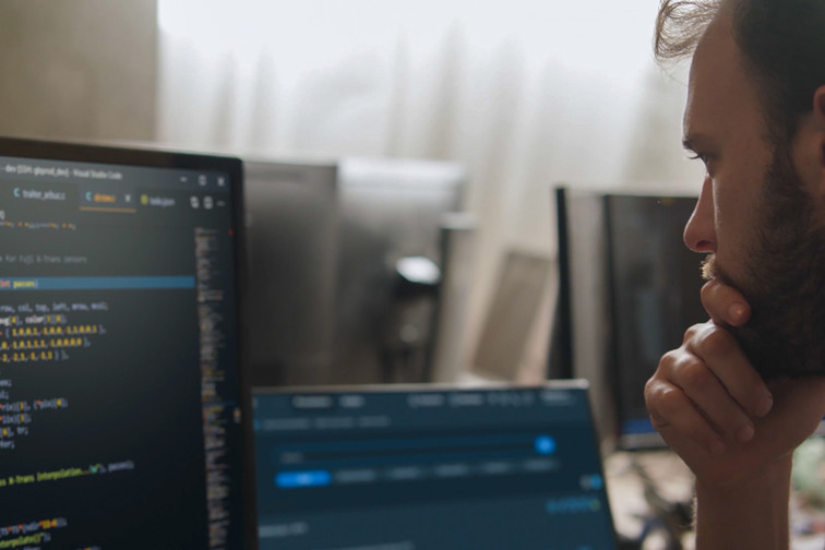 Man writing code on his computer, looking concentrated