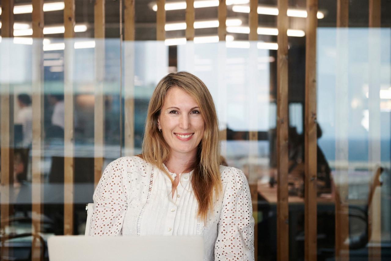 Woman in office, smiling at camera