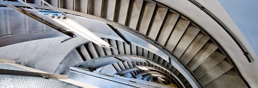 A spiral staircase leads down many floors in a classic building.